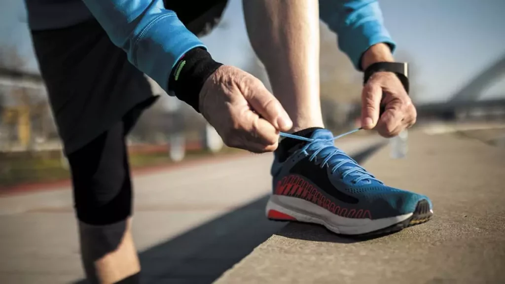 Homem amarrando tênis de corrida masculino durante o treino