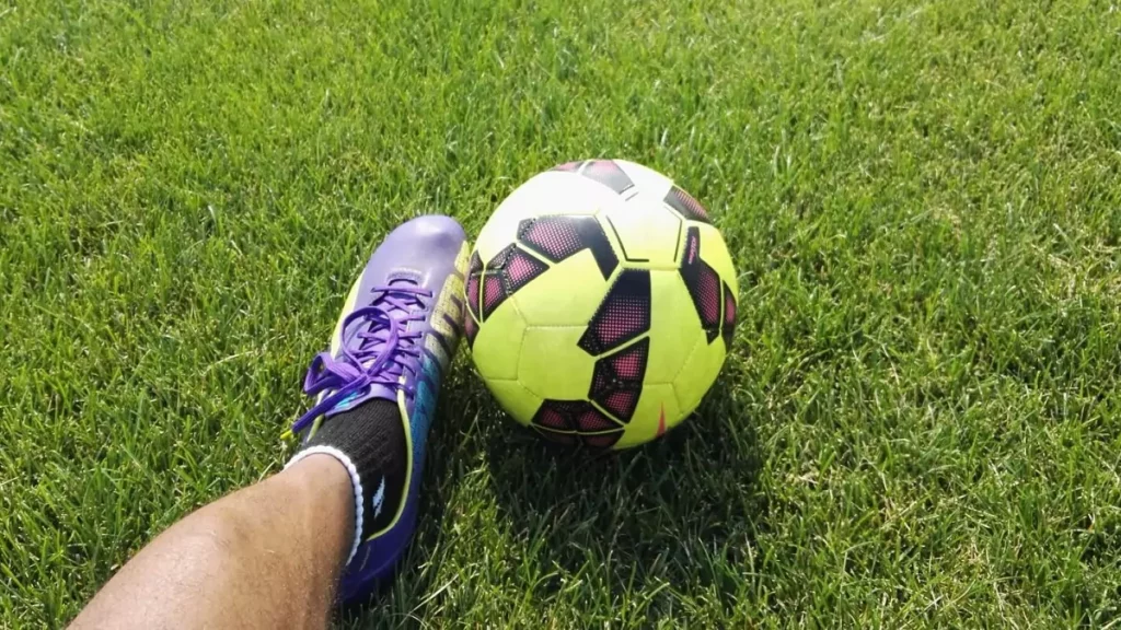 Homem dominando bola society em campo sintético