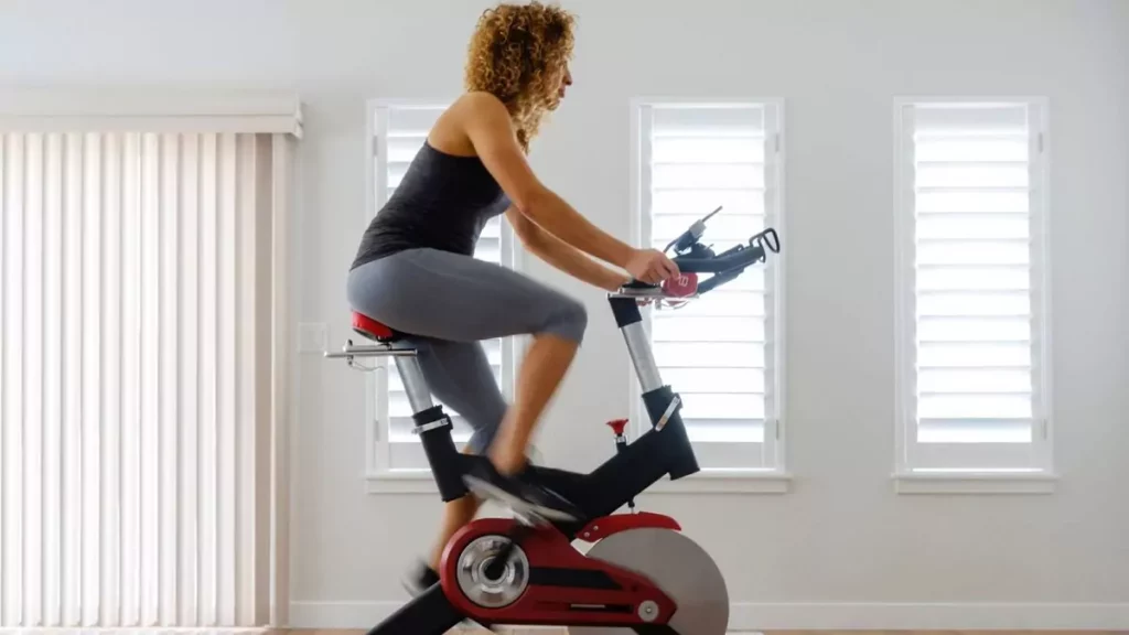Mulher praticando exercício em bicicleta ergométrica
